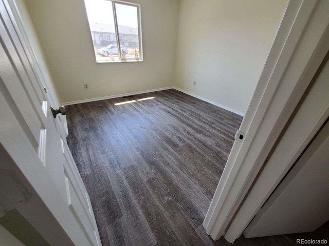 unfurnished room with dark hardwood / wood-style flooring