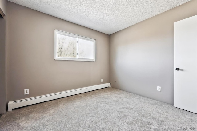 carpeted spare room with a baseboard radiator and a textured ceiling