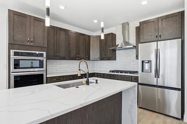 995 Pinehurst Ct, Bennett, CO 80102 - kitchen with appliances with stainless steel finishes, wall chimney range hood, dark brown cabinetry, decorative light fixtures, and decorative backsplash