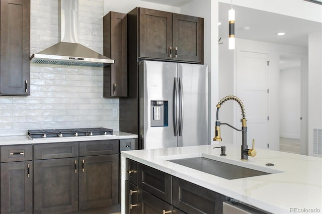 995 Pinehurst Ct, Bennett, CO 80102 - kitchen featuring wall chimney exhaust hood, appliances with stainless steel finishes, backsplash, dark brown cabinets, and hanging light fixtures