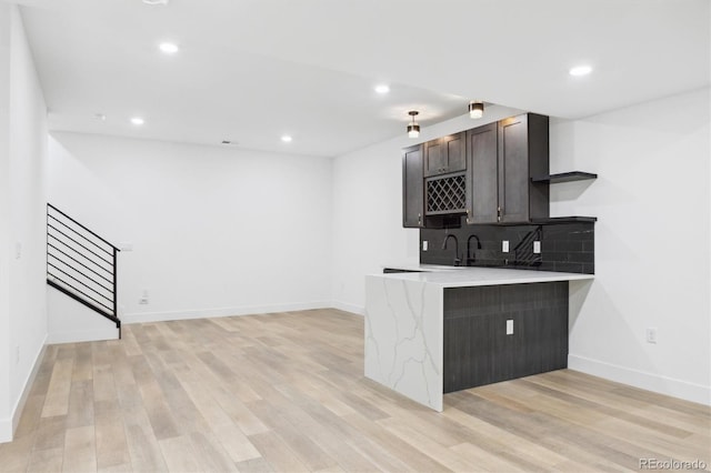 995 Pinehurst Ct, Bennett, CO 80102 - kitchen featuring light wood finished floors, backsplash, recessed lighting, a peninsula, and dark brown cabinetry