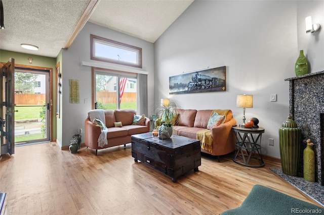 15149 E Princeton Pl Unit B, Aurora, CO 80014 - living area with wood finished floors, high vaulted ceiling, healthy amount of natural light, a textured ceiling, and baseboards