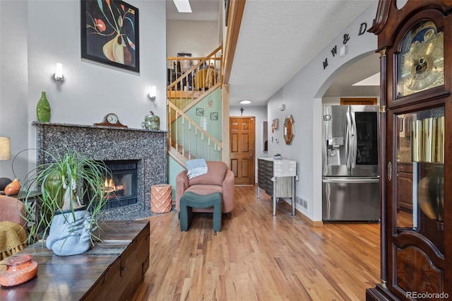 15149 E Princeton Pl Unit B, Aurora, CO 80014 - living area featuring stairs, light wood-style floors, arched walkways, and a tiled fireplace