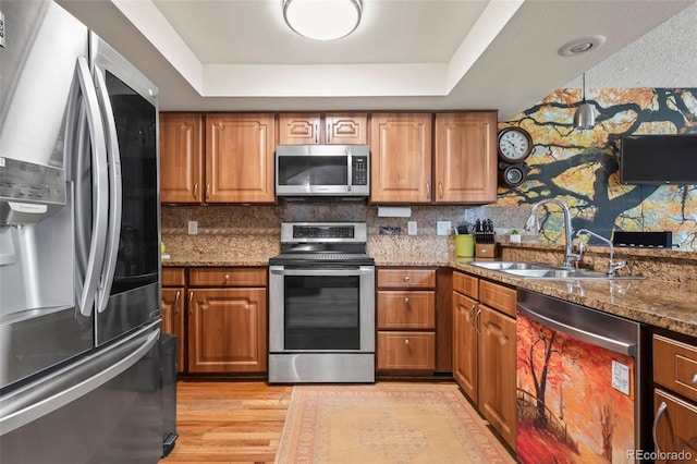 15149 E Princeton Pl Unit B, Aurora, CO 80014 - kitchen featuring appliances with stainless steel finishes, a sink, brown cabinets, and a raised ceiling
