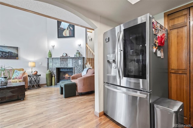 15149 E Princeton Pl Unit B, Aurora, CO 80014 - kitchen with stainless steel fridge with ice dispenser, light wood-type flooring, a fireplace with flush hearth, baseboards, and open floor plan