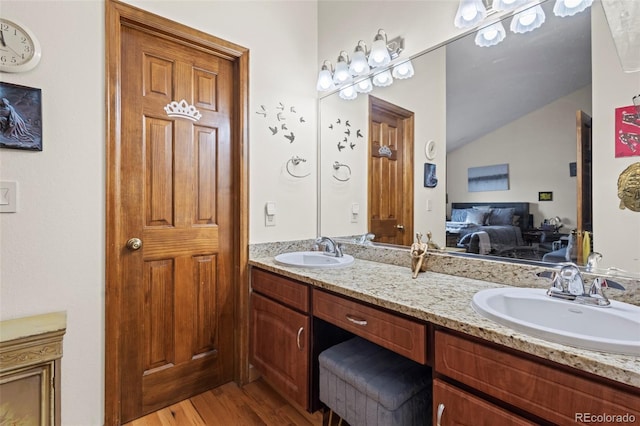 15149 E Princeton Pl Unit B, Aurora, CO 80014 - ensuite bathroom featuring wood finished floors, double vanity, and vaulted ceiling
