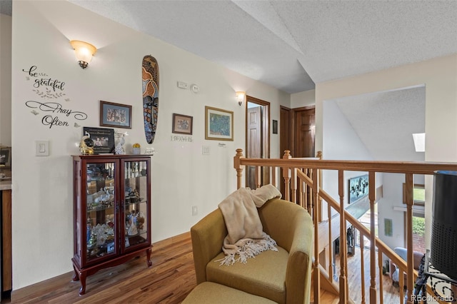 15149 E Princeton Pl Unit B, Aurora, CO 80014 - living area featuring wood finished floors, an upstairs landing, and a textured ceiling