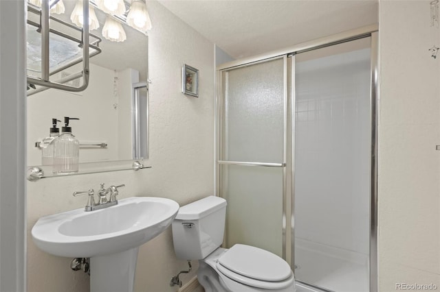 15149 E Princeton Pl Unit B, Aurora, CO 80014 - bathroom with a textured wall, a shower stall, toilet, and a sink