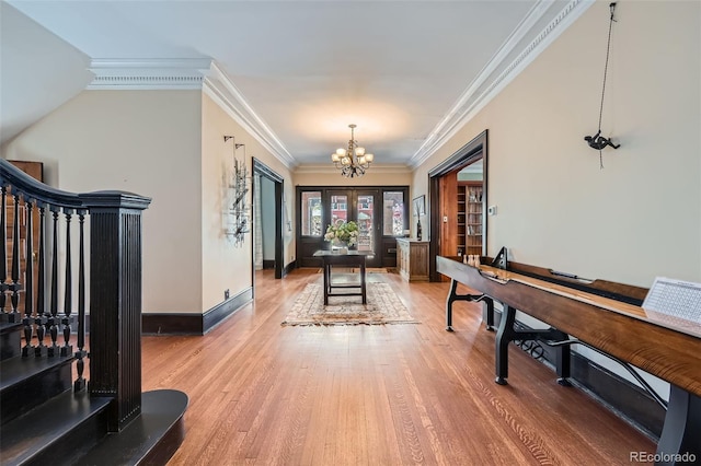 foyer with crown molding, a chandelier, light wood-style flooring, stairs, and baseboards