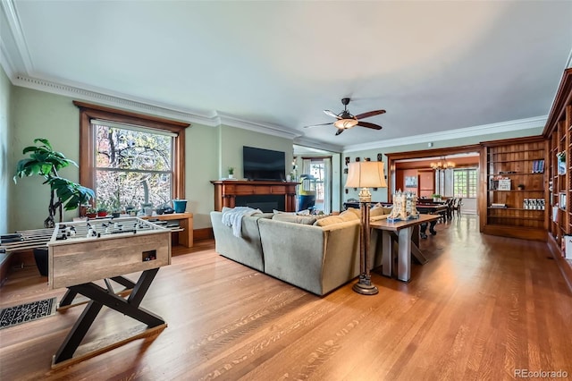 living room with ornamental molding, a healthy amount of sunlight, and light wood-style floors