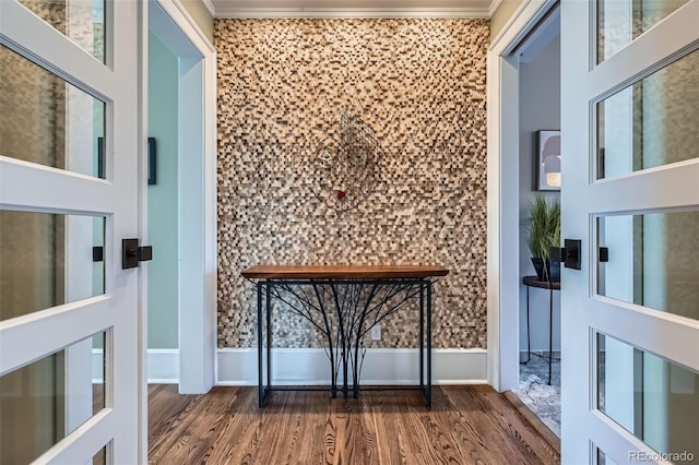 doorway to outside with crown molding and wood finished floors