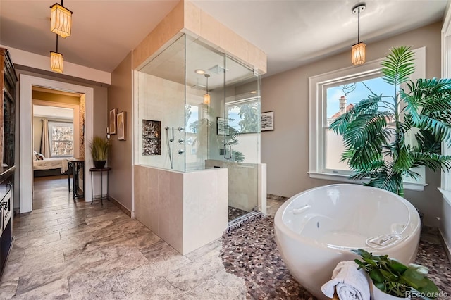 full bathroom featuring ensuite bathroom, a freestanding tub, walk in shower, and stone finish floor