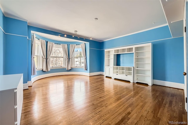 unfurnished bedroom featuring baseboards, ornamental molding, and wood finished floors