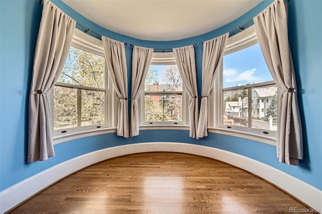 interior space with baseboards and wood finished floors