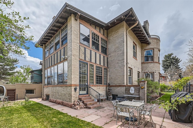 exterior space featuring brick siding, a chimney, a patio area, and entry steps
