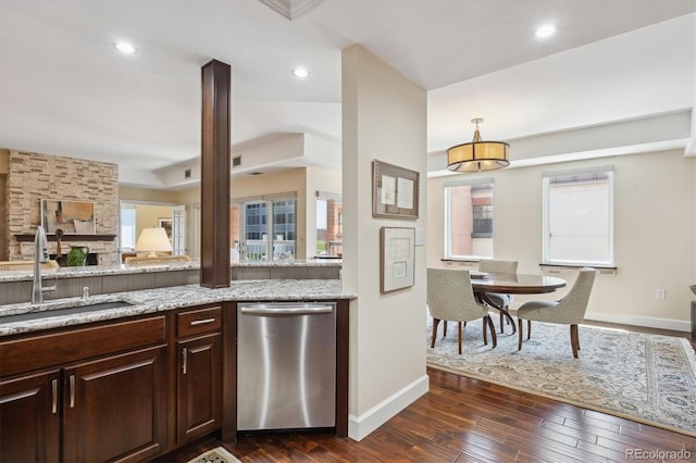 1512 Larimer St Unit 39, Denver, CO 80202 - kitchen with stainless steel dishwasher, a sink, dark wood-style floors, baseboards, and light stone countertops