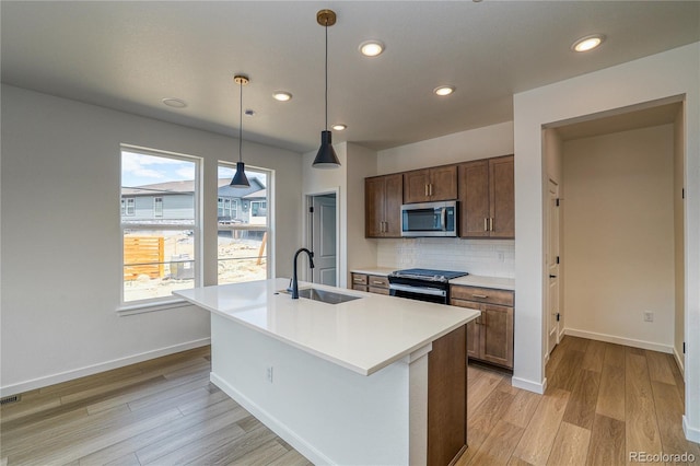 23909 E 41st Ave, Aurora, CO 80019 - kitchen with a sink, appliances with stainless steel finishes, light wood-style floors, baseboards, and light countertops