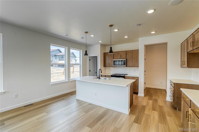 23909 E 41st Ave, Aurora, CO 80019 - kitchen featuring appliances with stainless steel finishes, a sink, recessed lighting, light wood-style floors, and tasteful backsplash