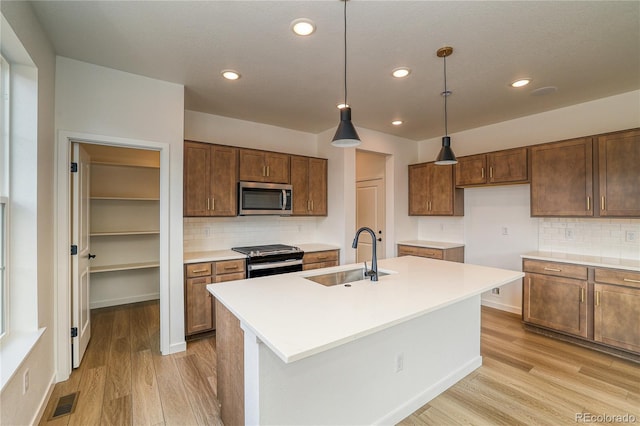 23909 E 41st Ave, Aurora, CO 80019 - kitchen with stainless steel appliances, a sink, light wood-style flooring, backsplash, and recessed lighting