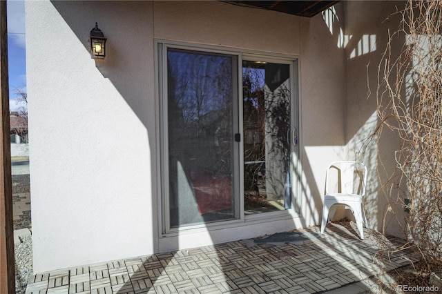 entrance to property featuring stucco siding