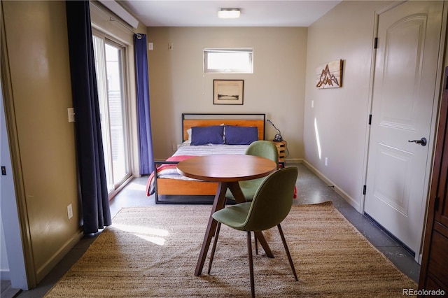 bedroom featuring baseboards, multiple windows, and concrete floors