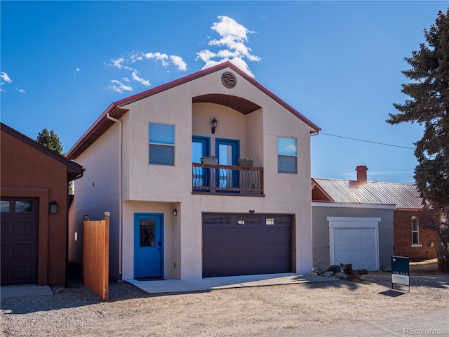 mediterranean / spanish-style house with a balcony, stucco siding, and an attached garage
