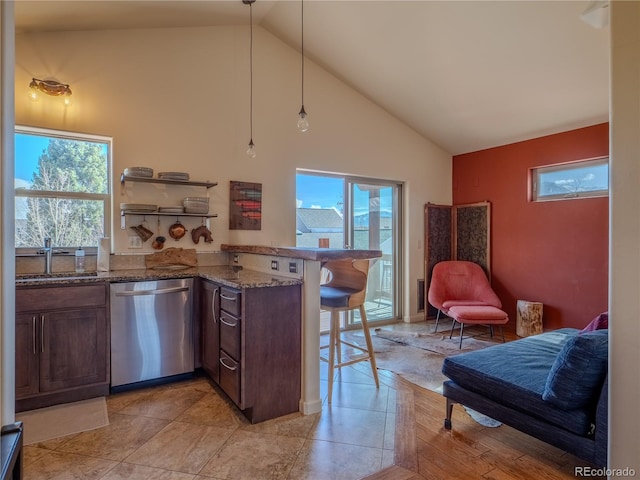 kitchen featuring high vaulted ceiling, a kitchen breakfast bar, a peninsula, dishwasher, and a sink