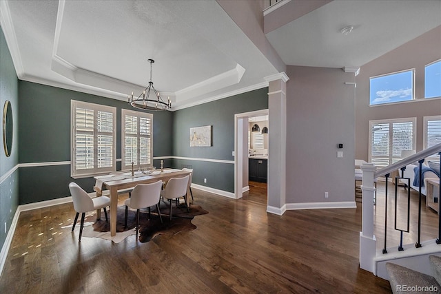 dining area featuring baseboards, a raised ceiling, wood finished floors, and stairs