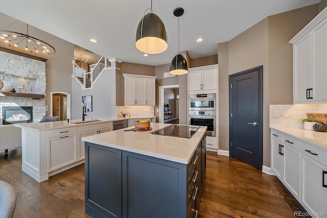 kitchen featuring a kitchen island, white cabinetry, stainless steel appliances, and open floor plan