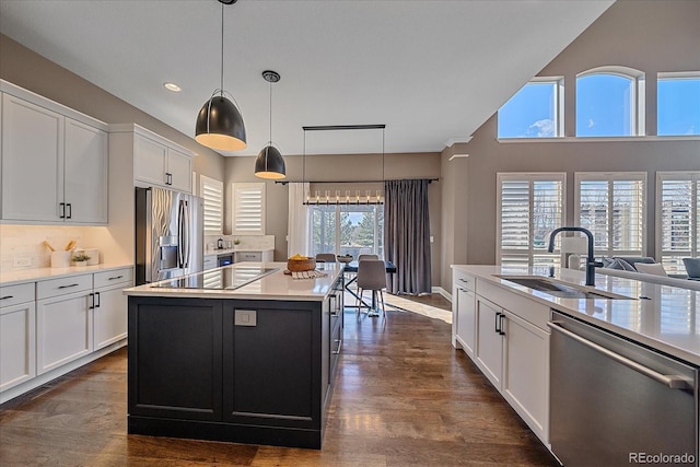 kitchen featuring light countertops, white cabinets, appliances with stainless steel finishes, and a sink