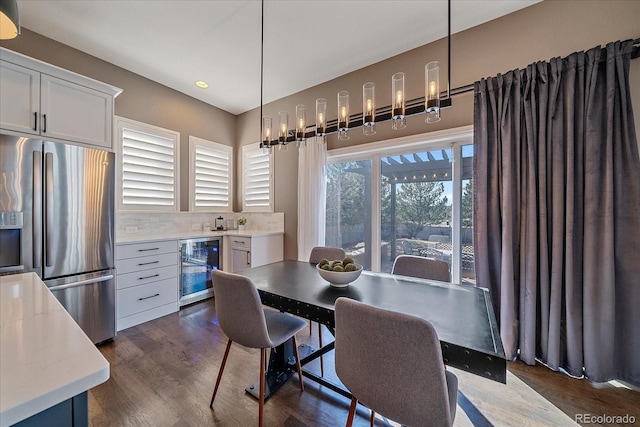 dining space with dark wood-type flooring and beverage cooler