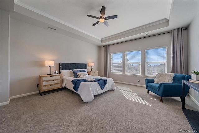 bedroom with a tray ceiling, crown molding, carpet, and baseboards