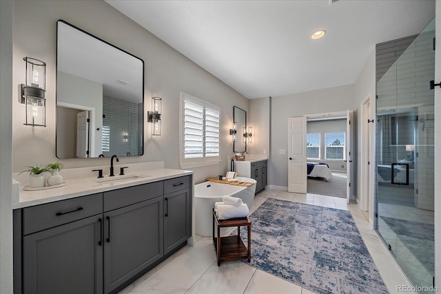 ensuite bathroom with a wealth of natural light, a shower stall, two vanities, and a sink