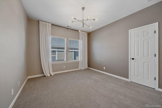 carpeted spare room with a chandelier, visible vents, and baseboards