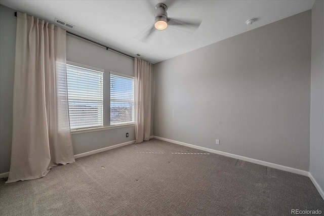 spare room with a ceiling fan, baseboards, visible vents, and carpet floors