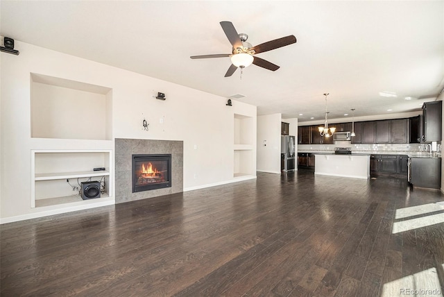 6370 Twilight Ave, Firestone, CO 80504 - unfurnished living room featuring built in features, dark wood finished floors, a ceiling fan, a tiled fireplace, and recessed lighting