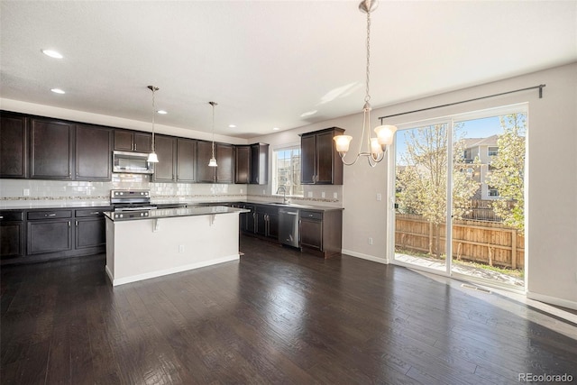 6370 Twilight Ave, Firestone, CO 80504 - kitchen featuring stainless steel appliances, a sink, a chandelier, dark brown cabinets, and a breakfast bar