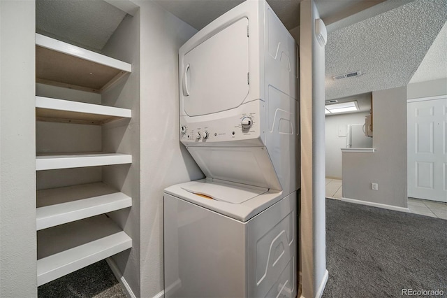 1970 S Xanadu Way Unit 101, Aurora, CO 80014 - laundry area featuring estacked washer and dryer, carpet flooring, and a textured ceiling