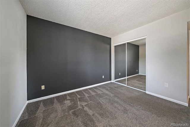 1970 S Xanadu Way Unit 101, Aurora, CO 80014 - unfurnished bedroom featuring dark carpet, a textured ceiling, and a closet