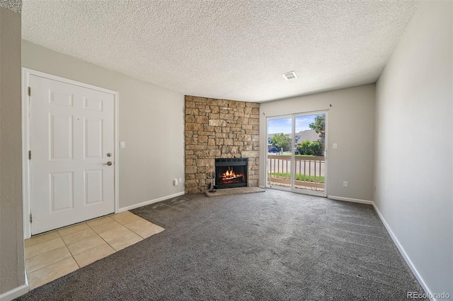 1970 S Xanadu Way Unit 101, Aurora, CO 80014 - unfurnished living room with carpet floors, a fireplace, a textured ceiling, and tile patterned flooring