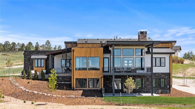 11115 Evening Hunt Rd, Franktown, CO 80116 - back of property with a chimney, a patio area, and a balcony