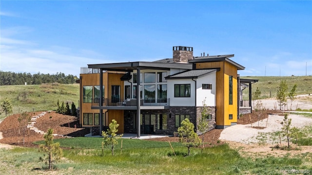 11115 Evening Hunt Rd, Franktown, CO 80116 - back of property featuring stone siding, a chimney, a balcony, and a patio area