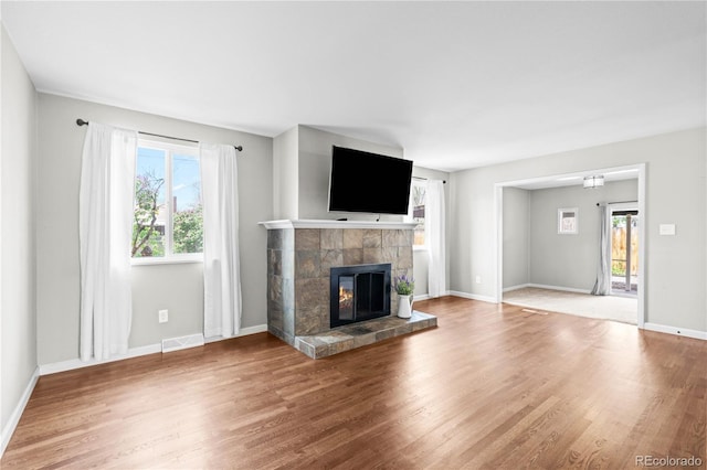 1765 S Endicott St, Lakewood, CO 80232 - unfurnished living room featuring a fireplace, wood finished floors, and baseboards