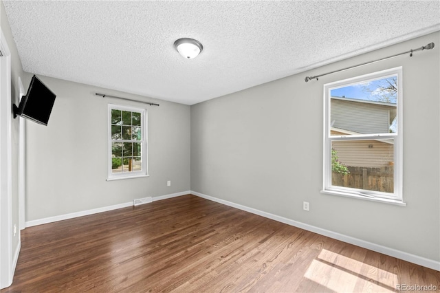 1765 S Endicott St, Lakewood, CO 80232 - empty room featuring wood finished floors, a textured ceiling, healthy amount of natural light, and baseboards