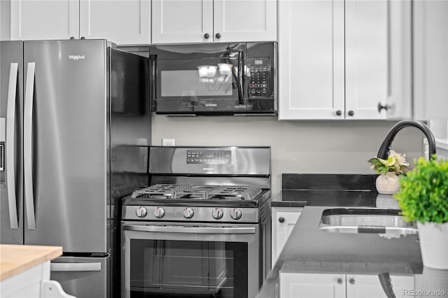 1765 S Endicott St, Lakewood, CO 80232 - kitchen featuring appliances with stainless steel finishes, white cabinets, a sink, and dark countertops