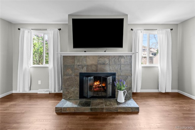 1765 S Endicott St, Lakewood, CO 80232 - detailed view of wood finished floors, a tiled fireplace, and baseboards