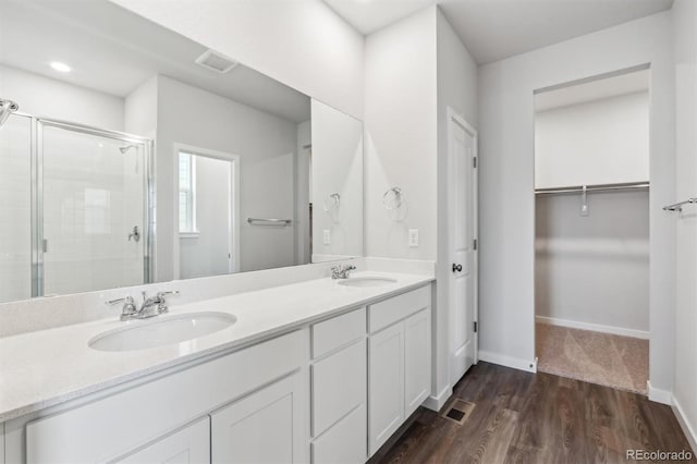 bathroom featuring hardwood / wood-style floors, vanity, and a shower with shower door