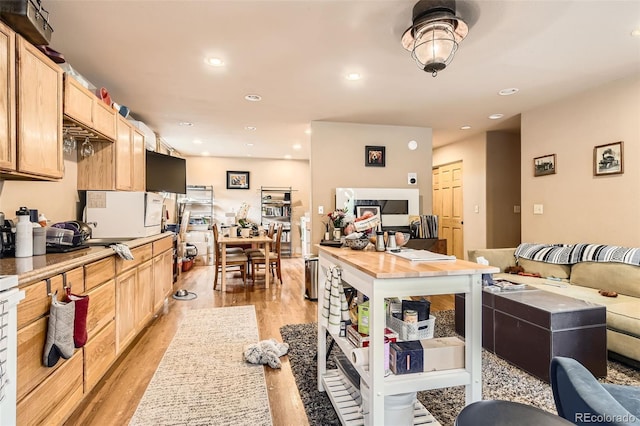 kitchen with light brown cabinets, light wood-style flooring, recessed lighting, open floor plan, and light countertops