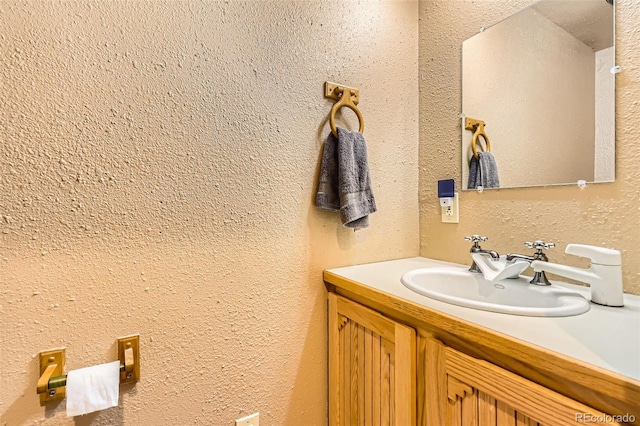 bathroom with vanity and a textured wall