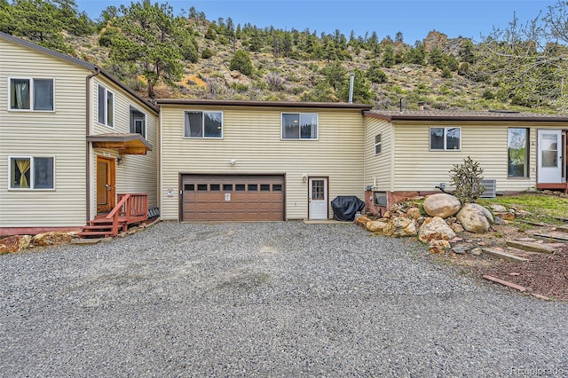 back of property with a garage and driveway